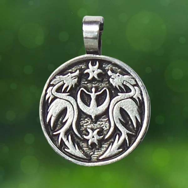 The Lady and the Dragon Peace with Myself is a round metal pendant showcasing two dragon like creatures positioned towards each other, surrounded by abstract symbols above and below, all set against a green bokeh backdrop.