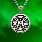 The 4 Elements Pendant, featuring geometric symbols in silver, hangs on a chain against a green smoky background.