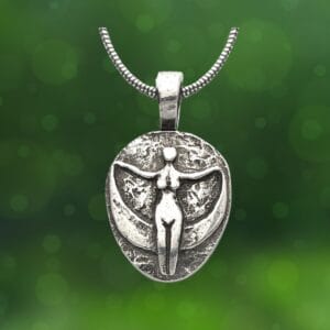 Avalon Moon Goddess Pendant featuring a figure resembling a person with outstretched arms set against a circular backdrop, suspended on a chain, with a green blurred background.