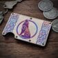 The Titanium Wolf Card Wallet, featuring a Celtic knot and stylized wolf design, sits on a wooden surface beside keys and Celtic themed coins.