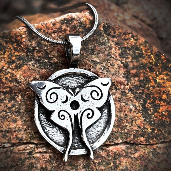 LunaMoth pendant against a wood background